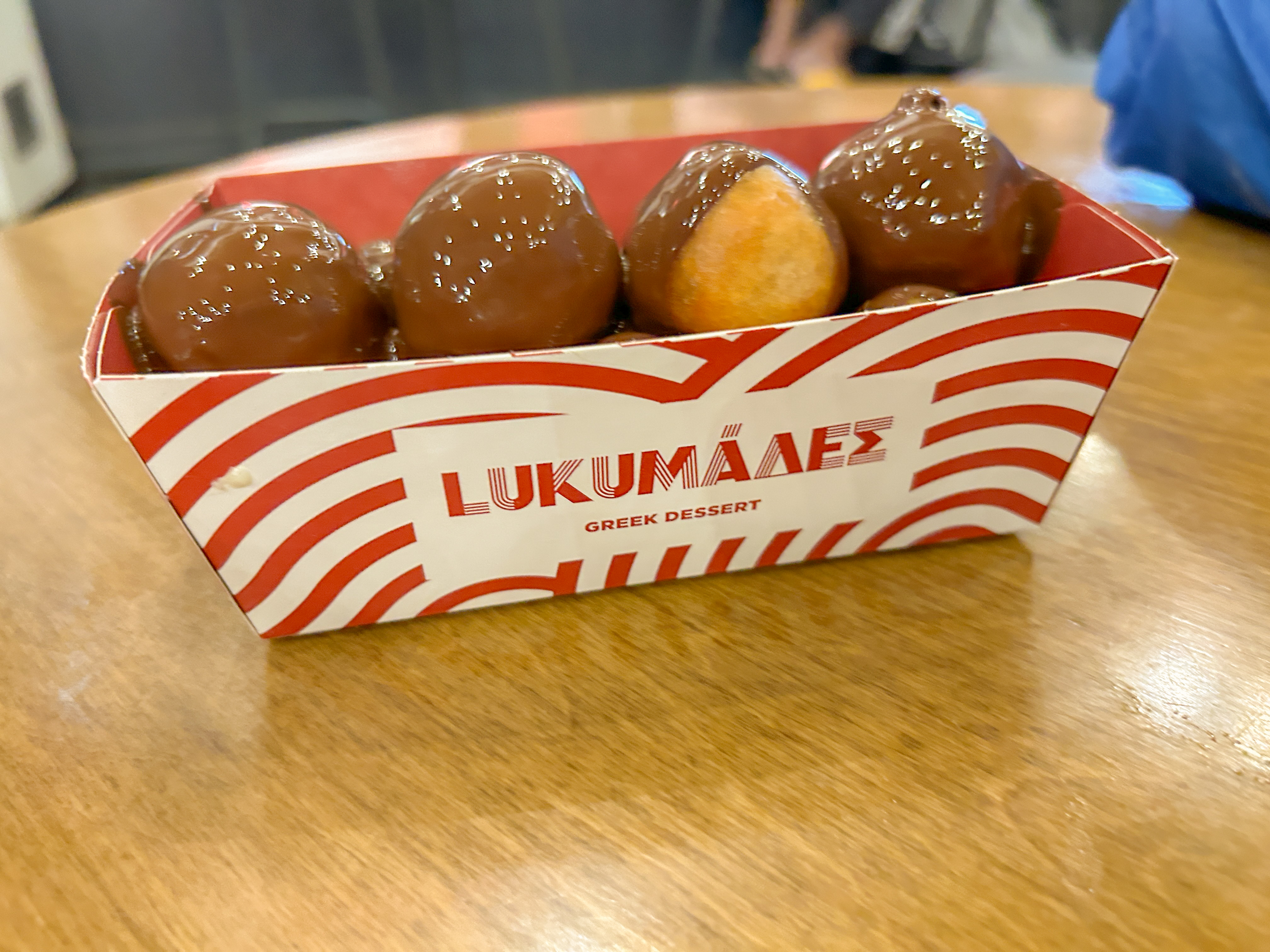 Small donut balls covered in liquid chocolate sauce in