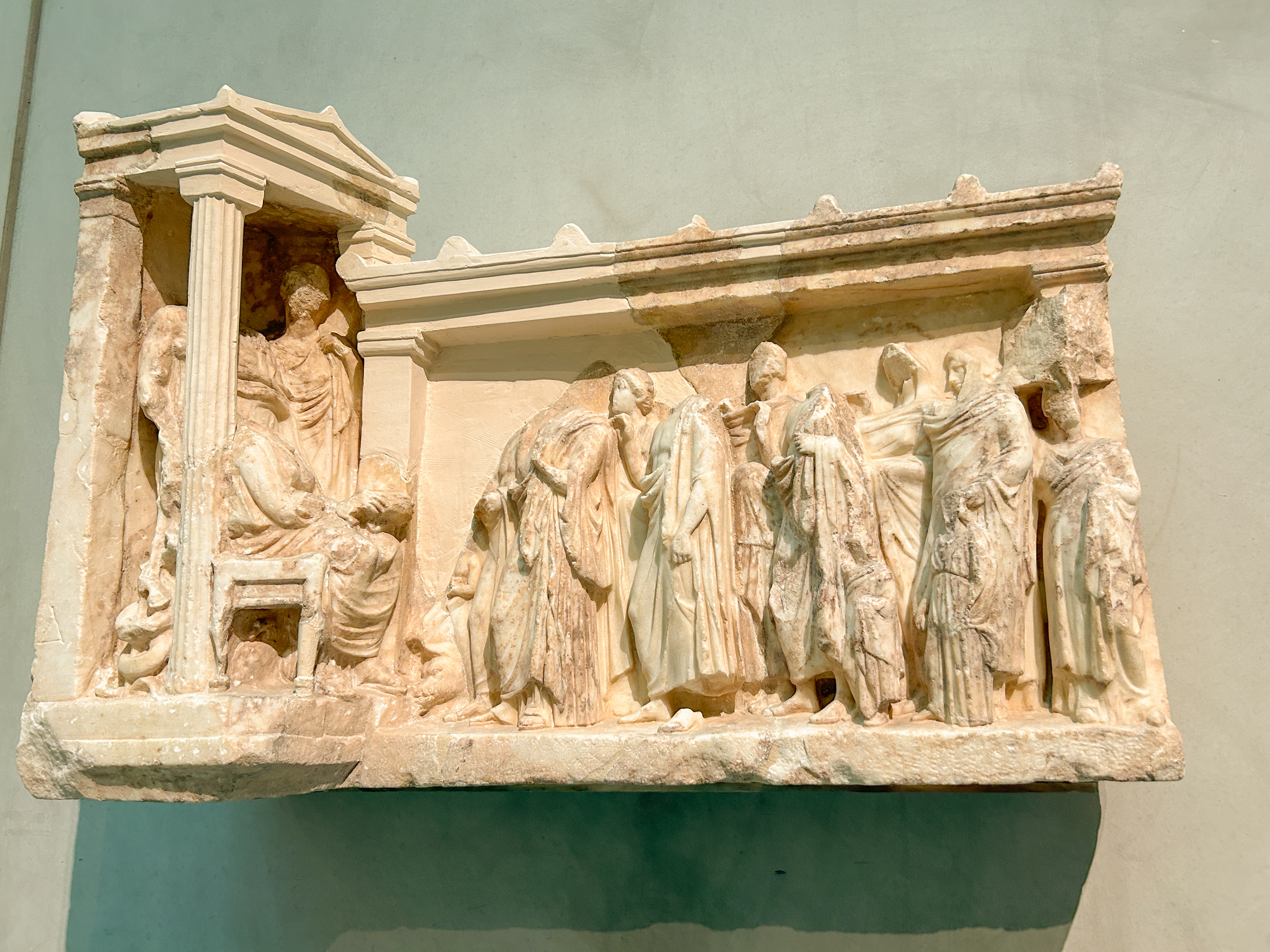 Relief sculpture called "Dedication to Asclepius" made of white marble.