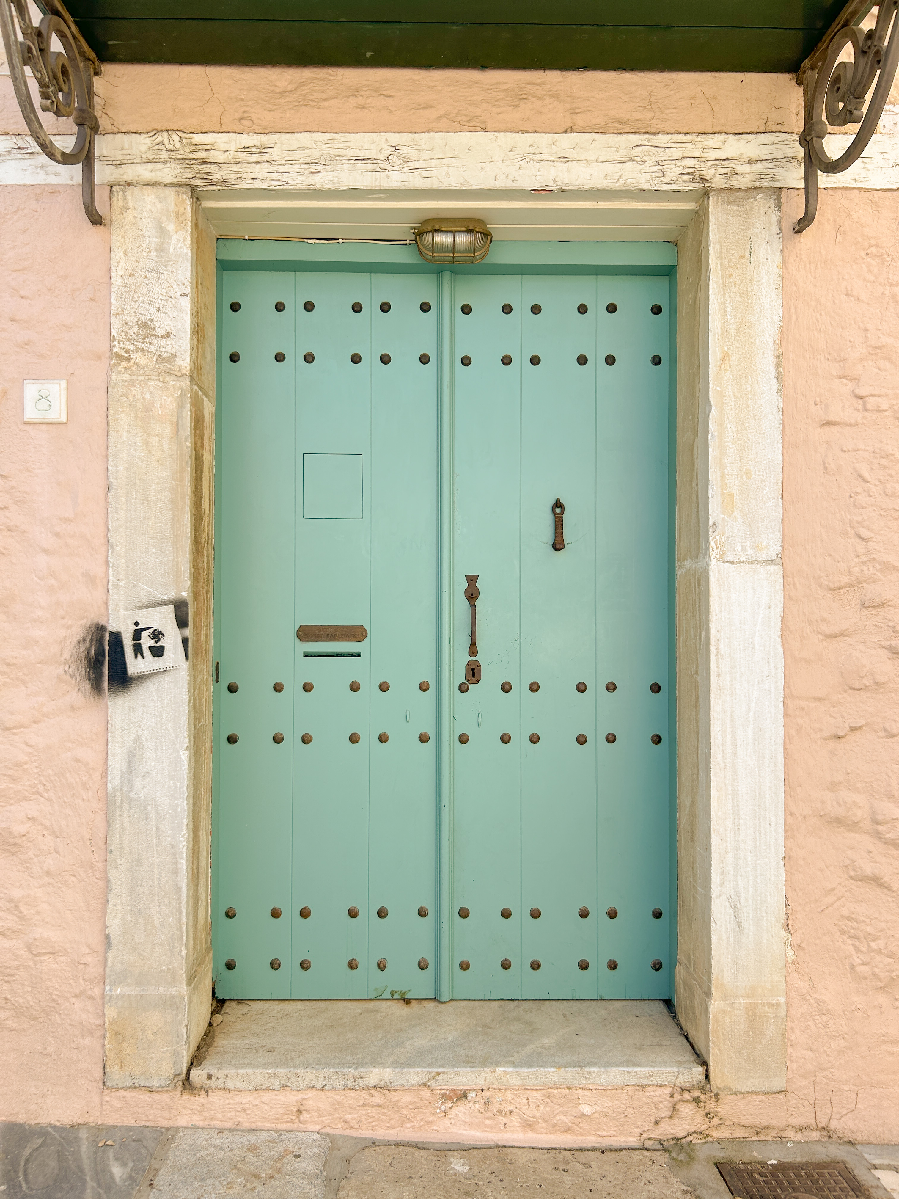 Blush pink house with turquoise blue door and white trim.
